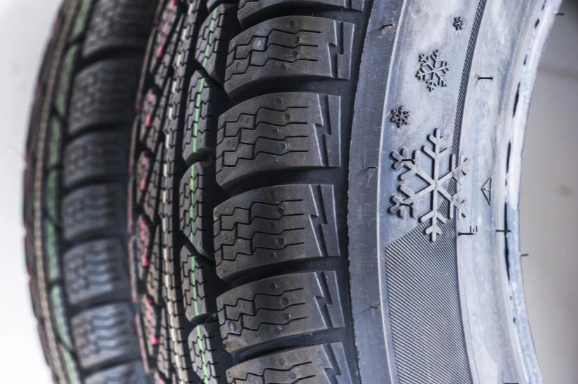 Zijkant van een winterband met sneeuwvloksymbolen in het loopvlak maar zonder officieel Alpine-keurmerk